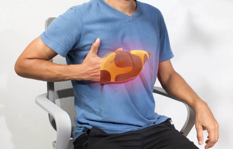 мужчина сидит на кресле и положил руку на область печени